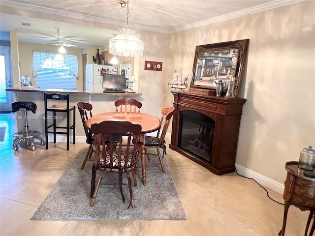 tiled dining room with crown molding and ceiling fan