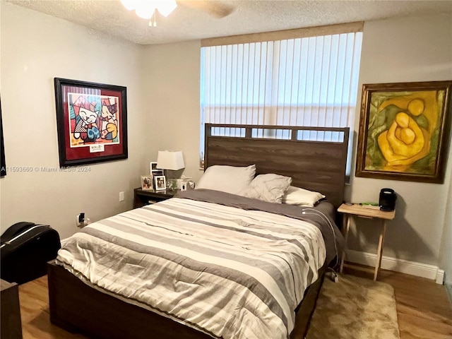 bedroom featuring a textured ceiling, ceiling fan, and hardwood / wood-style floors