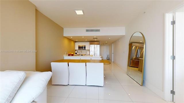 kitchen with white cabinetry, sink, light tile patterned floors, and stainless steel appliances