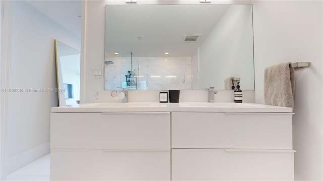 bathroom featuring tiled shower and vanity