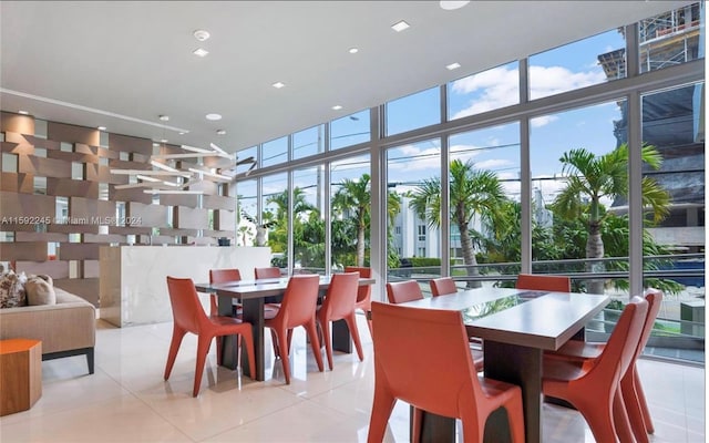 dining room with expansive windows, light tile patterned flooring, and a high ceiling