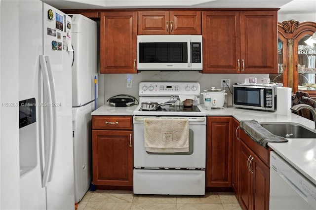 kitchen featuring sink, light tile flooring, and white appliances