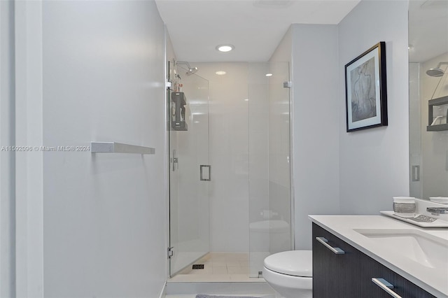 bathroom with tile flooring, vanity, toilet, and a shower with door