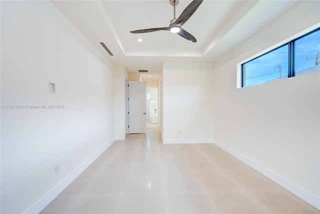 spare room featuring a tray ceiling and ceiling fan