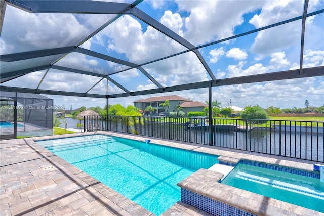 view of swimming pool featuring an in ground hot tub, a water view, glass enclosure, and a patio