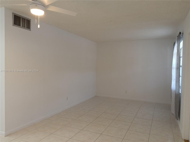 tiled empty room with ceiling fan