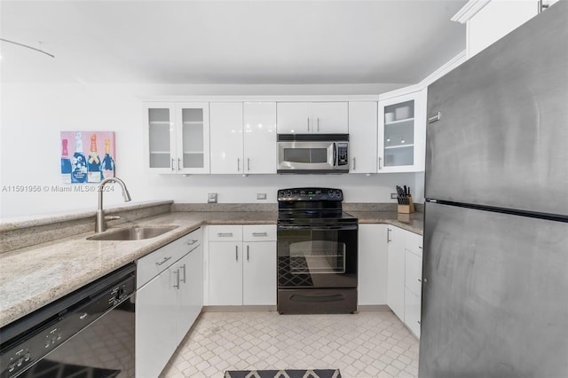 kitchen featuring white cabinetry, sink, black appliances, and light tile floors