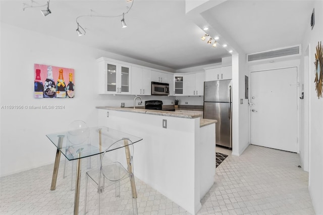 kitchen featuring stainless steel appliances, white cabinets, kitchen peninsula, light stone counters, and light tile flooring