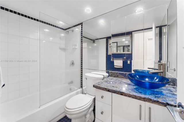 full bathroom with tile floors, tiled shower / bath, vanity, and toilet