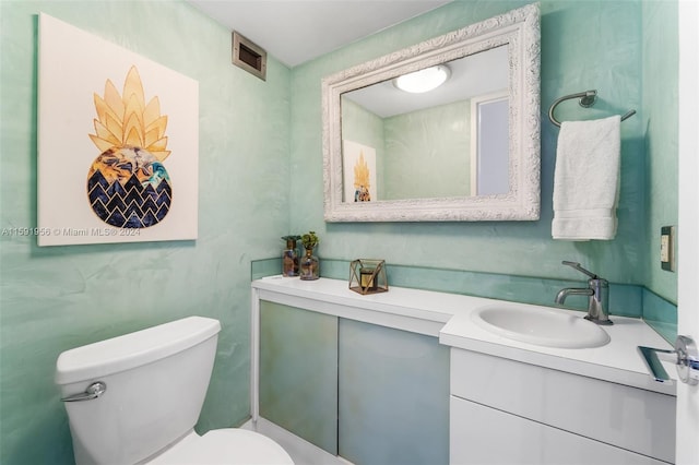 bathroom featuring vanity with extensive cabinet space and toilet