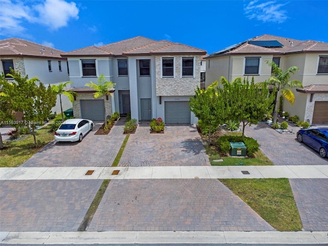 view of front facade featuring solar panels and a garage