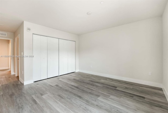 unfurnished bedroom featuring a closet and wood-type flooring