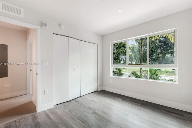 unfurnished bedroom with a closet and light wood-type flooring