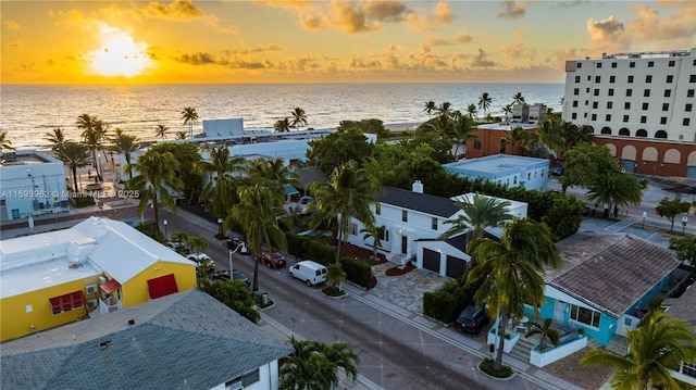 aerial view at dusk featuring a water view