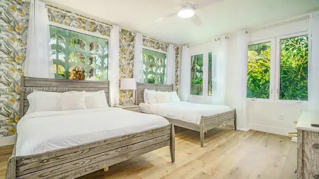 bedroom featuring multiple windows, wood-type flooring, and ceiling fan