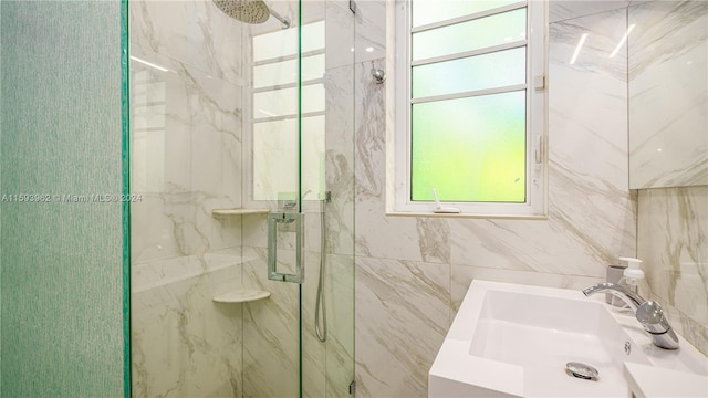 bathroom featuring tile walls, a shower with shower door, and sink