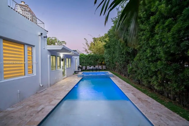 pool at dusk with a patio