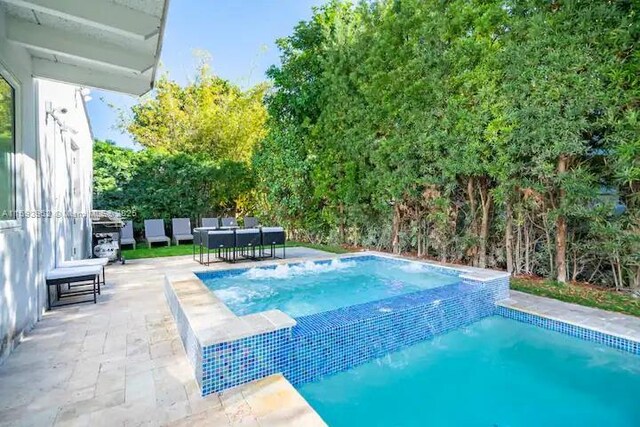 view of pool featuring area for grilling and a patio area