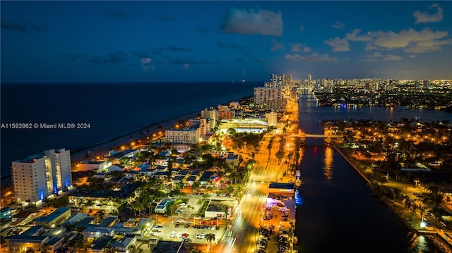 aerial view at night featuring a water view