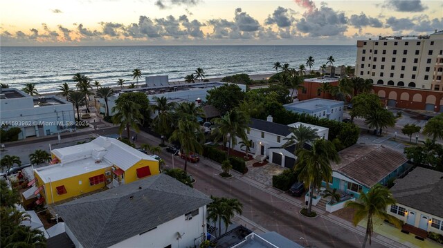 aerial view at dusk featuring a water view