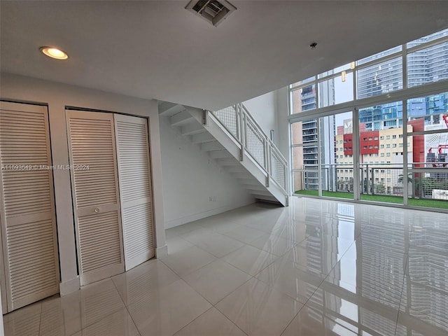 unfurnished living room with light tile patterned floors and a high ceiling