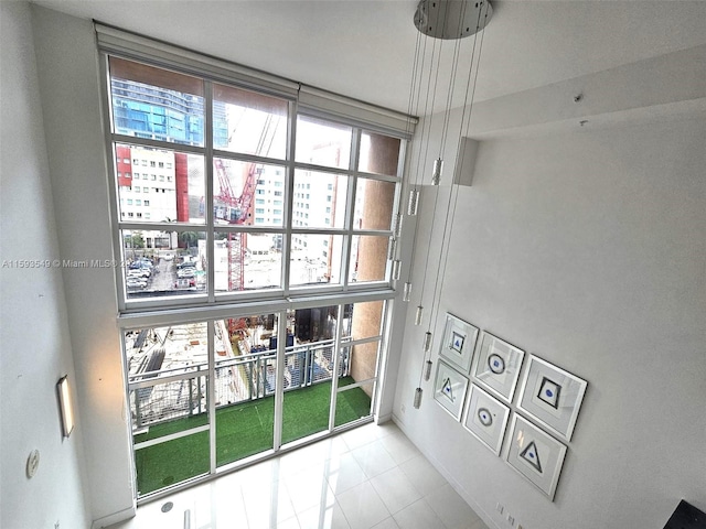 entrance foyer featuring light tile patterned flooring and a towering ceiling