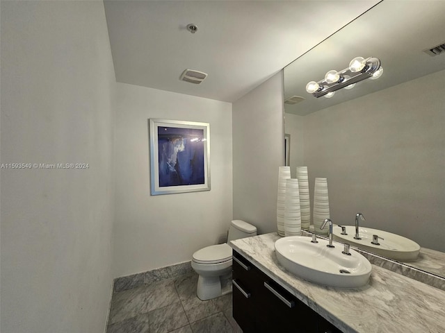 bathroom featuring tile patterned flooring, toilet, and vanity