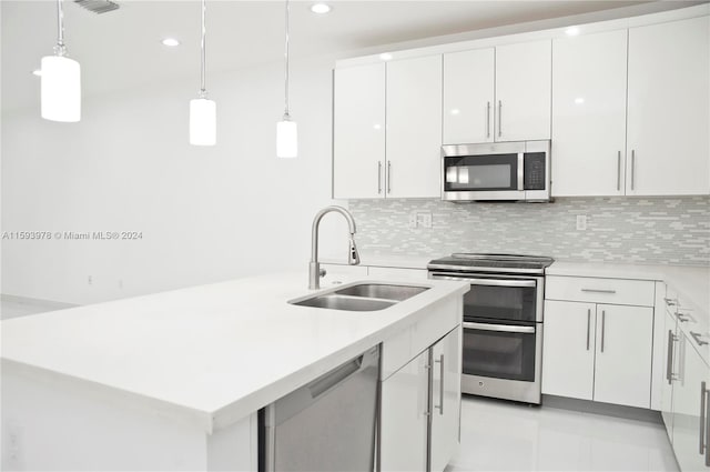 kitchen featuring stainless steel appliances, sink, backsplash, hanging light fixtures, and white cabinets