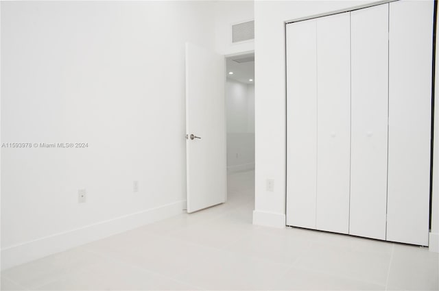 unfurnished bedroom featuring a closet and light tile patterned floors