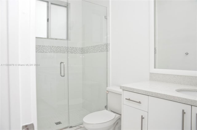 bathroom featuring walk in shower, vanity, and toilet