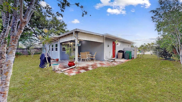 back of house featuring a patio area and a yard