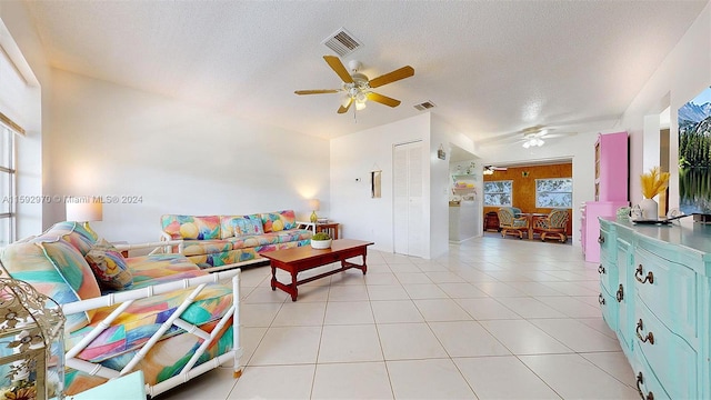 tiled living room featuring a textured ceiling and ceiling fan