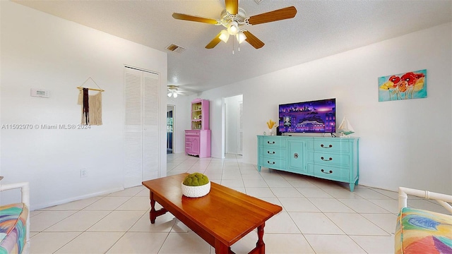 tiled living room featuring a textured ceiling and ceiling fan