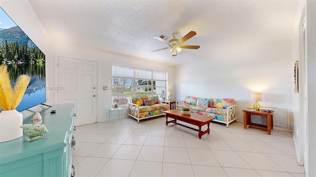 tiled living room with a textured ceiling and ceiling fan