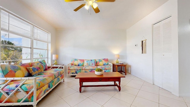 tiled living room featuring ceiling fan and a textured ceiling