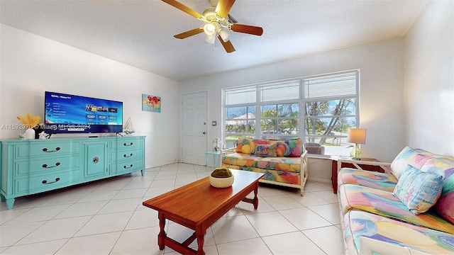 living room with a textured ceiling, ceiling fan, and light tile patterned floors