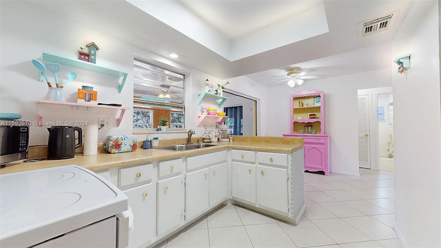 kitchen featuring white cabinetry, sink, light tile patterned floors, kitchen peninsula, and ceiling fan