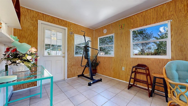 workout room featuring wooden walls and light tile patterned floors