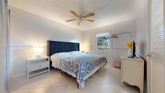 tiled bedroom with a textured ceiling and ceiling fan