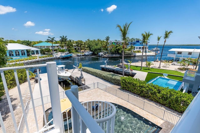 view of pool featuring a patio, a water view, and a dock