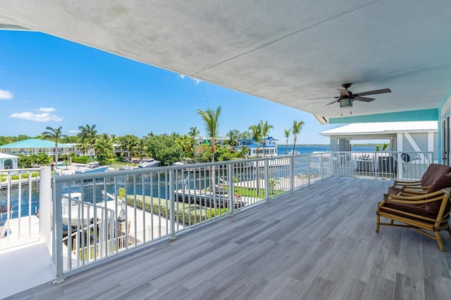 wooden terrace with a water view and ceiling fan