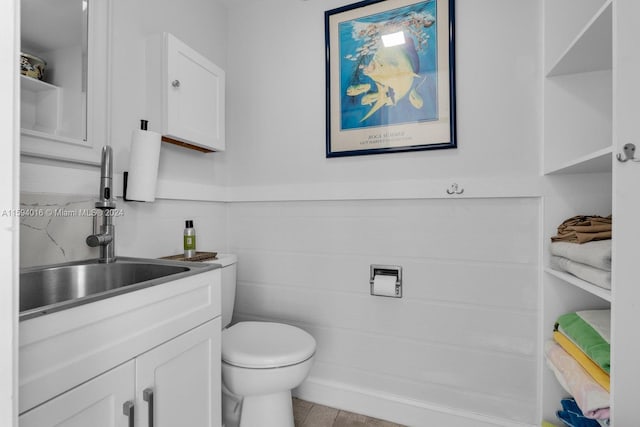 bathroom with tile floors, toilet, and vanity