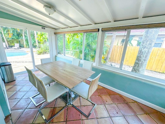 sunroom / solarium with a healthy amount of sunlight and lofted ceiling with beams