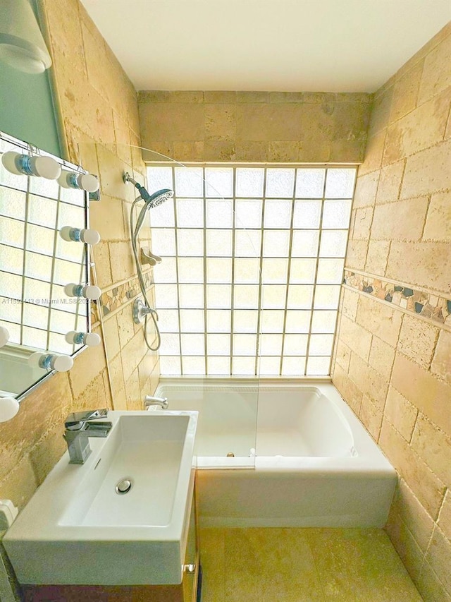 bathroom featuring tile flooring, sink, tile walls, and tiled shower / bath combo