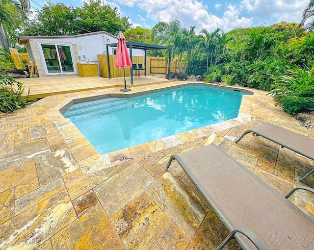 view of pool with a wooden deck and a patio area