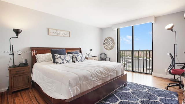 bedroom with access to exterior and hardwood / wood-style floors