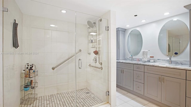 bathroom with a shower with door, dual bowl vanity, and tile floors