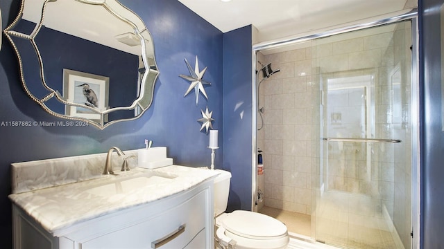 bathroom with an enclosed shower, large vanity, and toilet