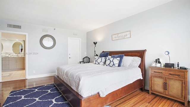 bedroom with sink, wood-type flooring, and ensuite bath