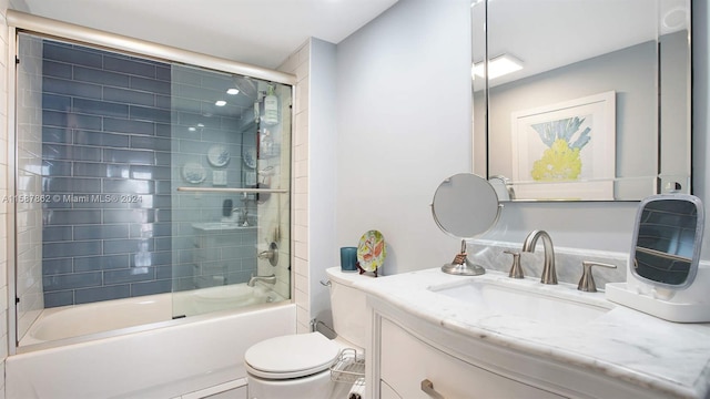 full bathroom with combined bath / shower with glass door, vanity, and toilet